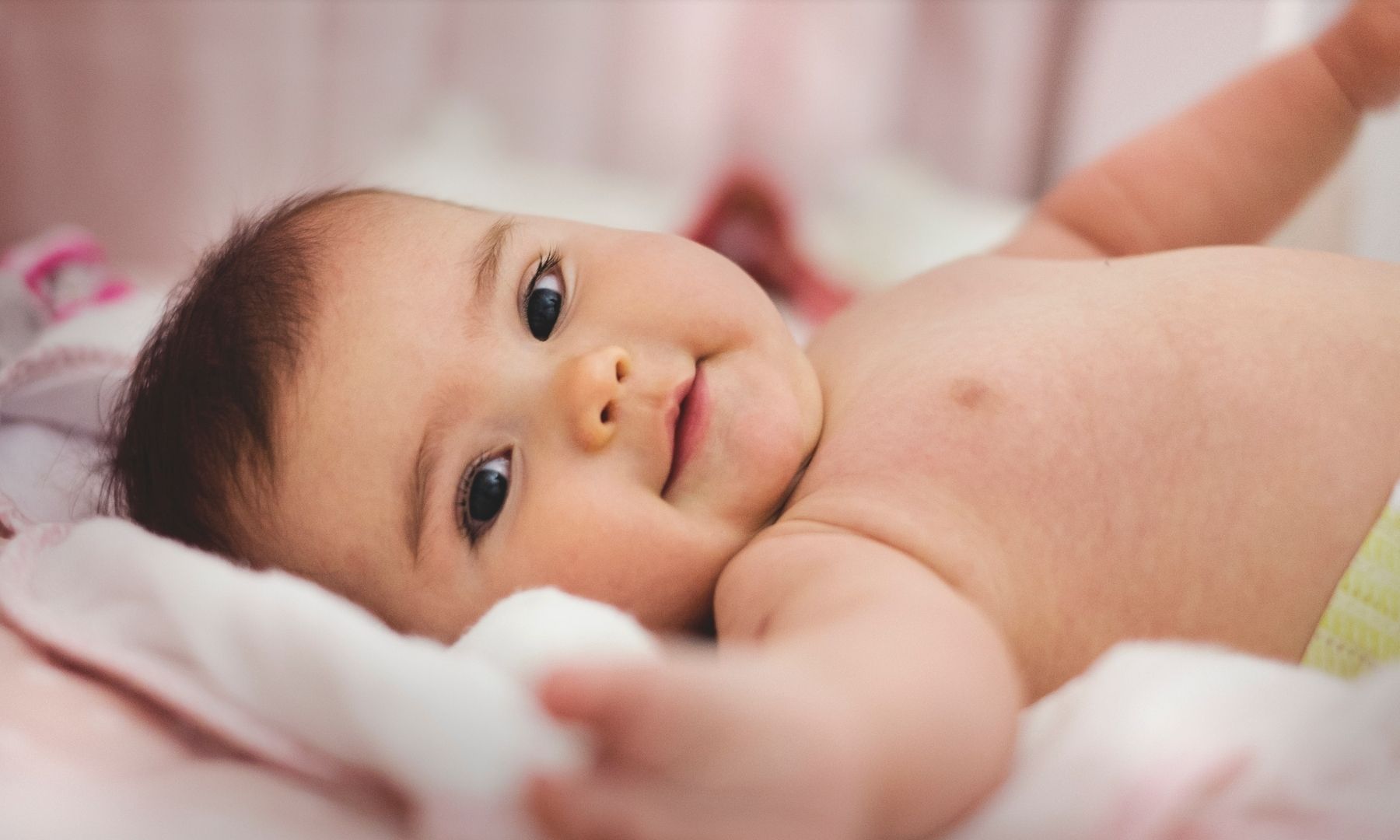 Smiling baby reaching out towards the camera