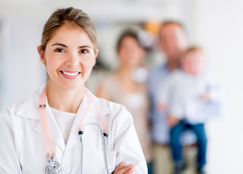 Female doctor smiling with family in background